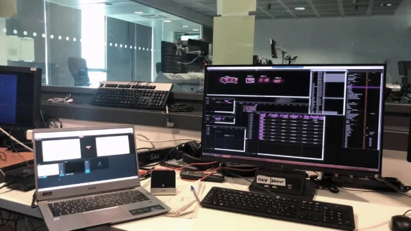Puesto de control con pantallas de software de monitoreo en PLC para diagnóstico industrial en tiempo real.