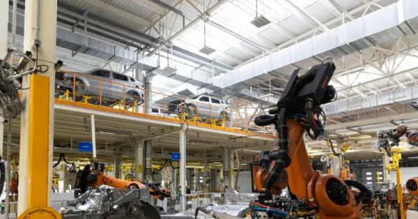 Brazo robótico en línea de ensamblaje automotriz optimizando la calidad de componentes mediante herramientas de control SPC.