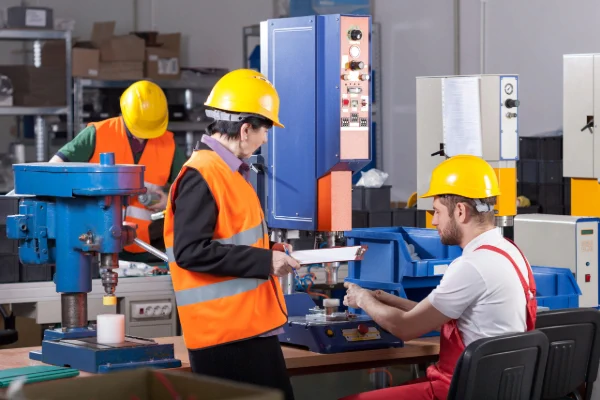 Trabajadores en planta industrial asegurando el cumplimiento de normativas locales e internacionales en producción.
