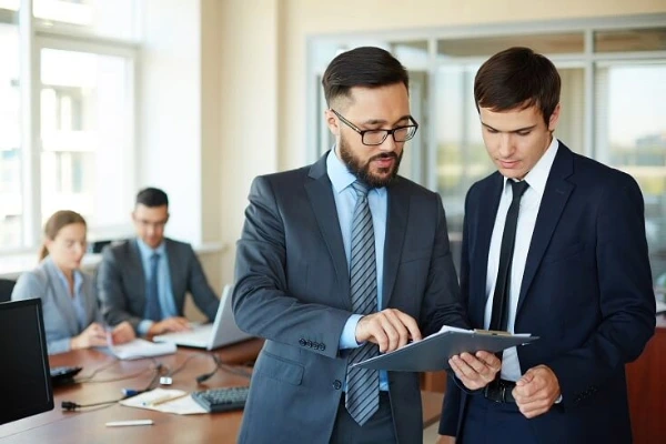 Profesionales en oficina revisando documentación para implementar sistemas de calidad certificados según ISO 9001 y otros estándares internacionales.